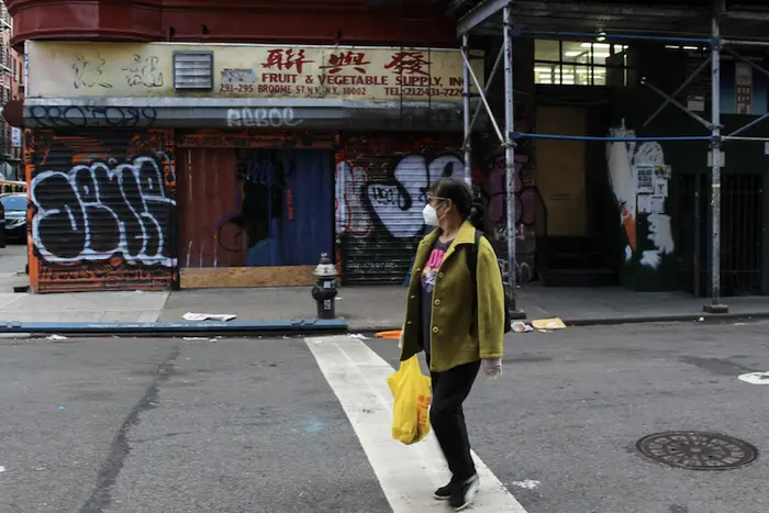 A woman walks past closed businesses in Chinatown.